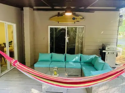 a hammock on a patio with a blue couch at Beach Apartment with Pool and Lake - Playa Hermosa in Muñeco