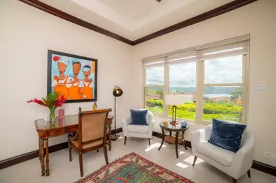 a living room with a desk and chairs and a window at Terrazas 1A - 3 bedroom - seven day minimum in La Mona