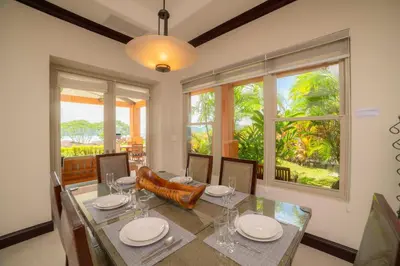 a dining room with a table and chairs and windows at Terrazas 1A - 3 bedroom - seven day minimum in La Mona