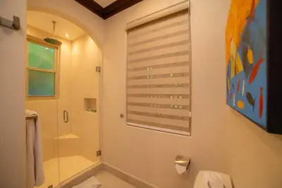 a bathroom with a shower and a toilet and a window at Terrazas 1A - 3 bedroom - seven day minimum in La Mona