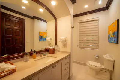 a bathroom with a sink and a toilet and a mirror at Terrazas 1A - 3 bedroom - seven day minimum in La Mona