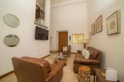 a living room with leather furniture and a tv at Veranda 1C - 3 bdr 3 bath in La Mona