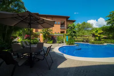 a patio with a table and an umbrella next to a pool at Veranda 1C - 3 bdr 3 bath in La Mona