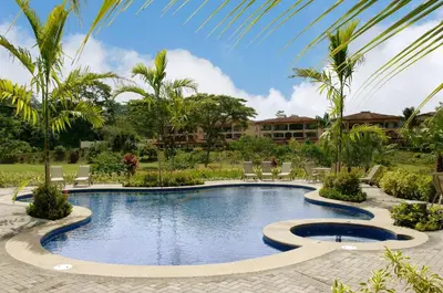 a pool at a resort with chairs and palm trees at Veranda 1C - 3 bdr 3 bath in La Mona
