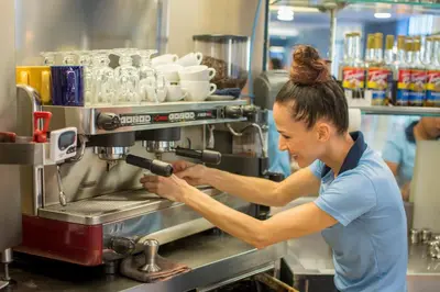 a woman operates a coffee machine in a kitchen at Veranda 1E 3bdr 3 bath in La Mona