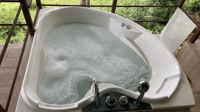 a bath tub filled with water with a faucet at Casita El Perezoso in San Rafael