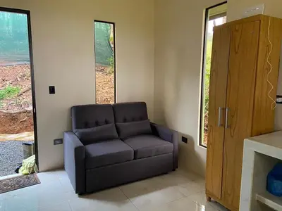 a living room with a couch in a room with windows at La Casita El Perezoso in San Rafael