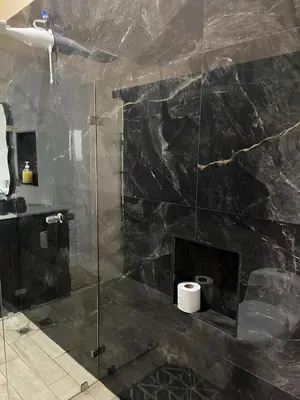 a bathroom with a glass shower with a fireplace at La Casita El Perezoso in San Rafael