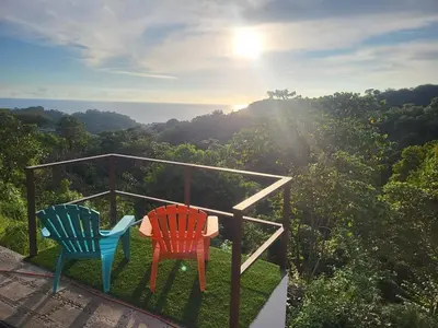 two chairs sitting on top of a balcony with a view at Casa Pura Vista in Playa Hermosa