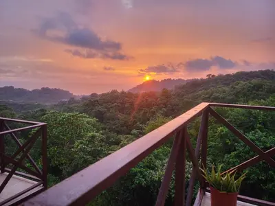 a view of a sunset from a wooden bridge at Casa Pura Vista in Playa Hermosa