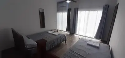 a room with two beds and a large window at Casa iguana in Potrero