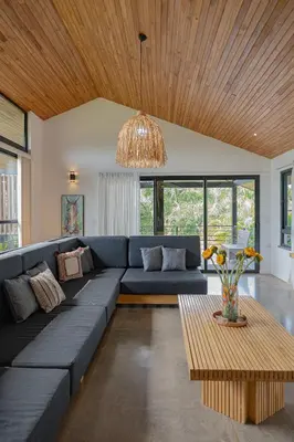a living room with a blue couch and a table at Villa Bernard - luxurious home walking distance to the beach in Tamarindo