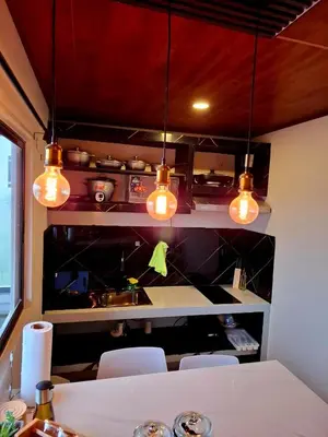 a kitchen with a table with chairs and lights at My Costa Rica Home Place in Tetsalia