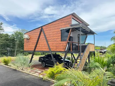 a tiny house with a truck parked in front of it at Villa Oropéndola Sarapiquí in Colonia Carvajal