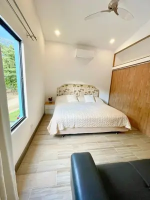 a bedroom with a bed and a large window at Tesoro Escondido in Naranjito