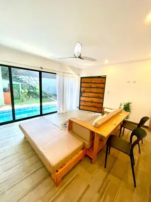 a room with two beds and a table and chairs at Tesoro Escondido in Naranjito