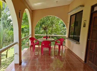 a dining room with red chairs and a table at El Diamante - Colibri in Playa Hermosa