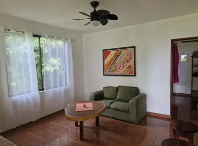 a living room with a green couch and a table at El Diamante - Colibri in Playa Hermosa