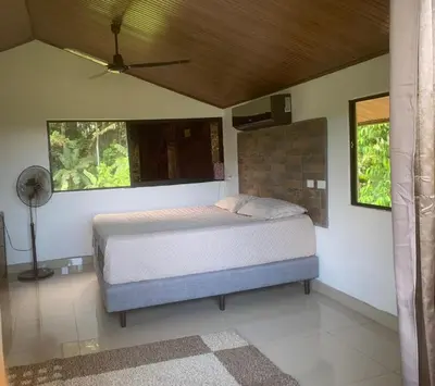 a bedroom with a bed and a fan at Apartamento Paseo Damitas in Parrita