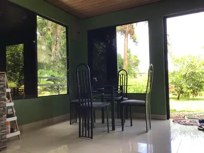 a table and chairs in a room with windows at Apartamento Paseo Damitas in Parrita