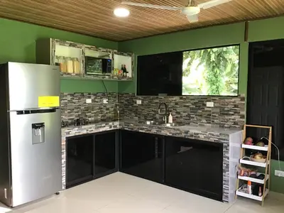 a kitchen with black cabinets and a refrigerator at Apartamento Paseo Damitas in Parrita