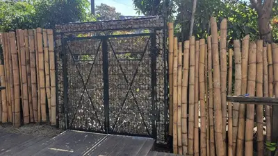 a gate in a fence with a bunch of logs at Jardin De Poas Hotel & Nature Resort in Poás