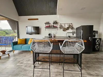 a kitchen with a table and chairs in a living room at Jardin De Poas Hotel & Nature Resort in Poás