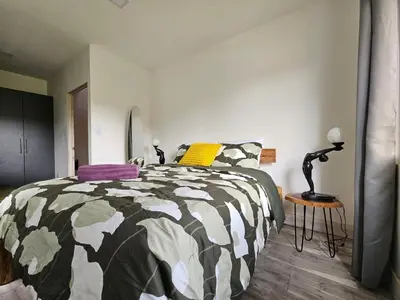 a bedroom with a bed with a black and white comforter at Jardin De Poas Hotel & Nature Resort in Poás