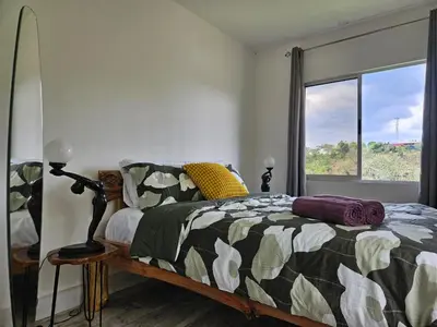 a bedroom with a bed and a window at Jardin De Poas Hotel & Nature Resort in Poás