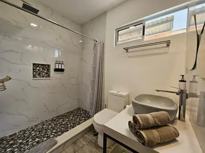 a bathroom with a shower and a toilet and a sink at Jardin De Poas Hotel & Nature Resort in Poás