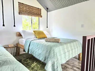 a bedroom with two beds and a window at Jardin De Poas Hotel & Nature Resort in Poás