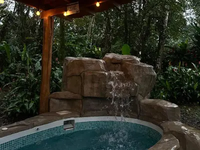 a swimming pool with a water fountain at Cabin with private tropical forest in Tanque