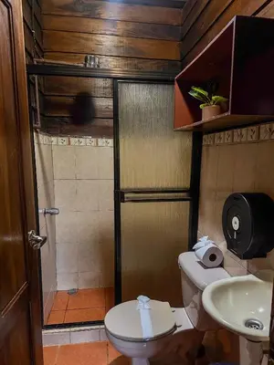 a bathroom with a shower and a toilet and a sink at Cabin with private tropical forest in Tanque
