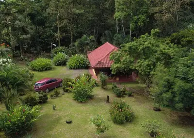 a red truck parked in front of a small house at Cabin with private tropical forest in Tanque