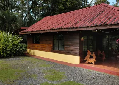 a small wooden house with a red roof at Cabin with private tropical forest in Tanque