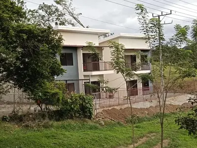 a white building with a fence in front of it at Vista Serena la Guácima in Alajuela City
