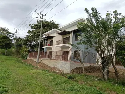 a house with a fence and a tree in front of it at Vista Serena la Guácima in Alajuela City