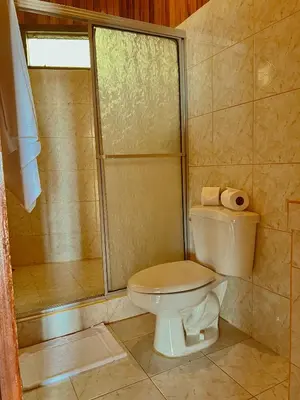 a bathroom with a toilet and a shower at Hotel El Atardecer in Monteverde Costa Rica