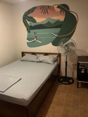 a bedroom with a bed with a painting on the wall at Private Room One block from the beach in Coco