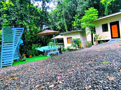 a house with a picnic table and an umbrella at Monstera Forest Lodge in Fortuna