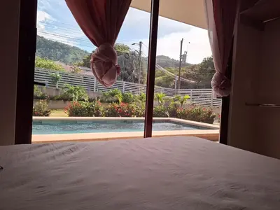 a bedroom with a bed and a view of a pool at Casa Pura Vida in Coco