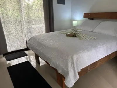 a bedroom with a bed with a flower arrangement on it at Bungalows Chachagüita in Chachagua