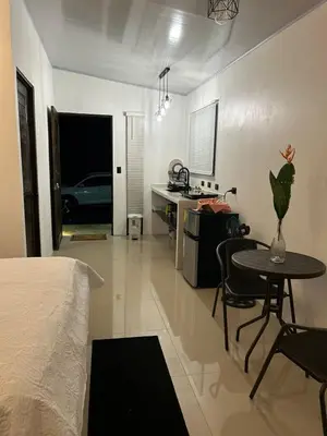 a bedroom with a bed and a table and a kitchen at Bungalows Chachagüita in Chachagua