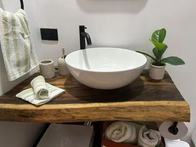 a bathroom with a white bowl sink on a wooden counter at Bungalows Chachagüita in Chachagua