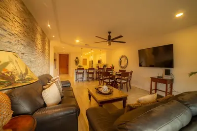 a living room with a leather couch and a table at Del Mar 4M - 3 bdr 2 bath Condo in Herradura
