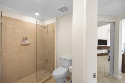 a bathroom with a toilet and a glass shower at Del Mar 5F 3 bedr 2 bath in Herradura