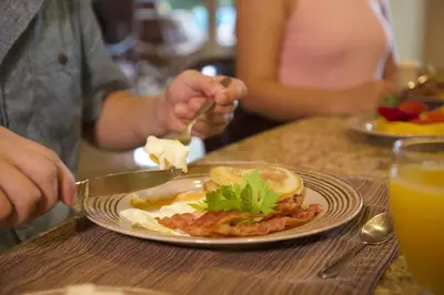 a person eating a plate of food on a table at Del Mar 5F 3 bedr 2 bath in Herradura