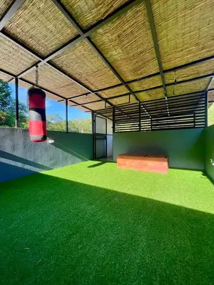 a room with green flooring and a large ceiling at Jaco Roca Bruja in Jacó