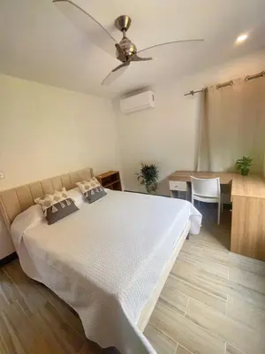 a bedroom with a bed with a ceiling fan at Jaco Roca Bruja in Jacó