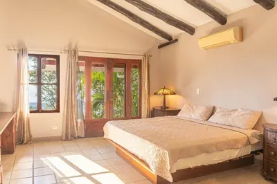 a bedroom with a bed and a window at Casa Nubes - Ocean View in Carrillo